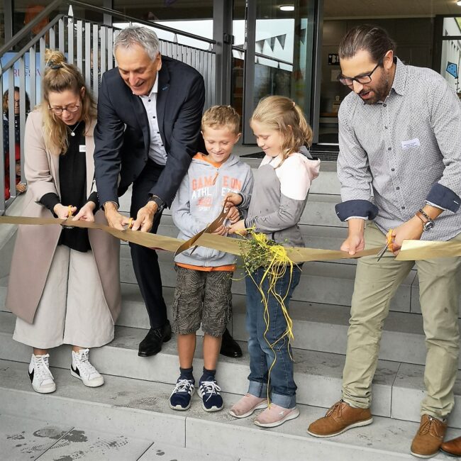 Zerschneiden des Bands zum Schulhaus