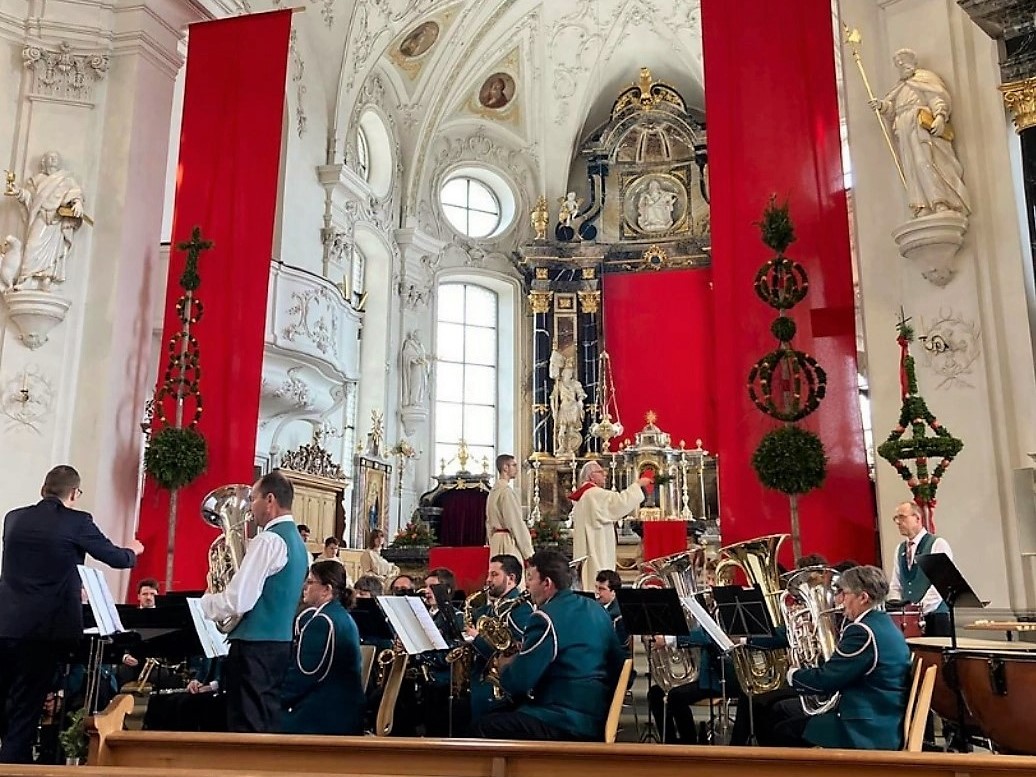 Pfarrer Toni Bucher segnet die Palmen während den Klängen der Ortsmusik Rüediswil.